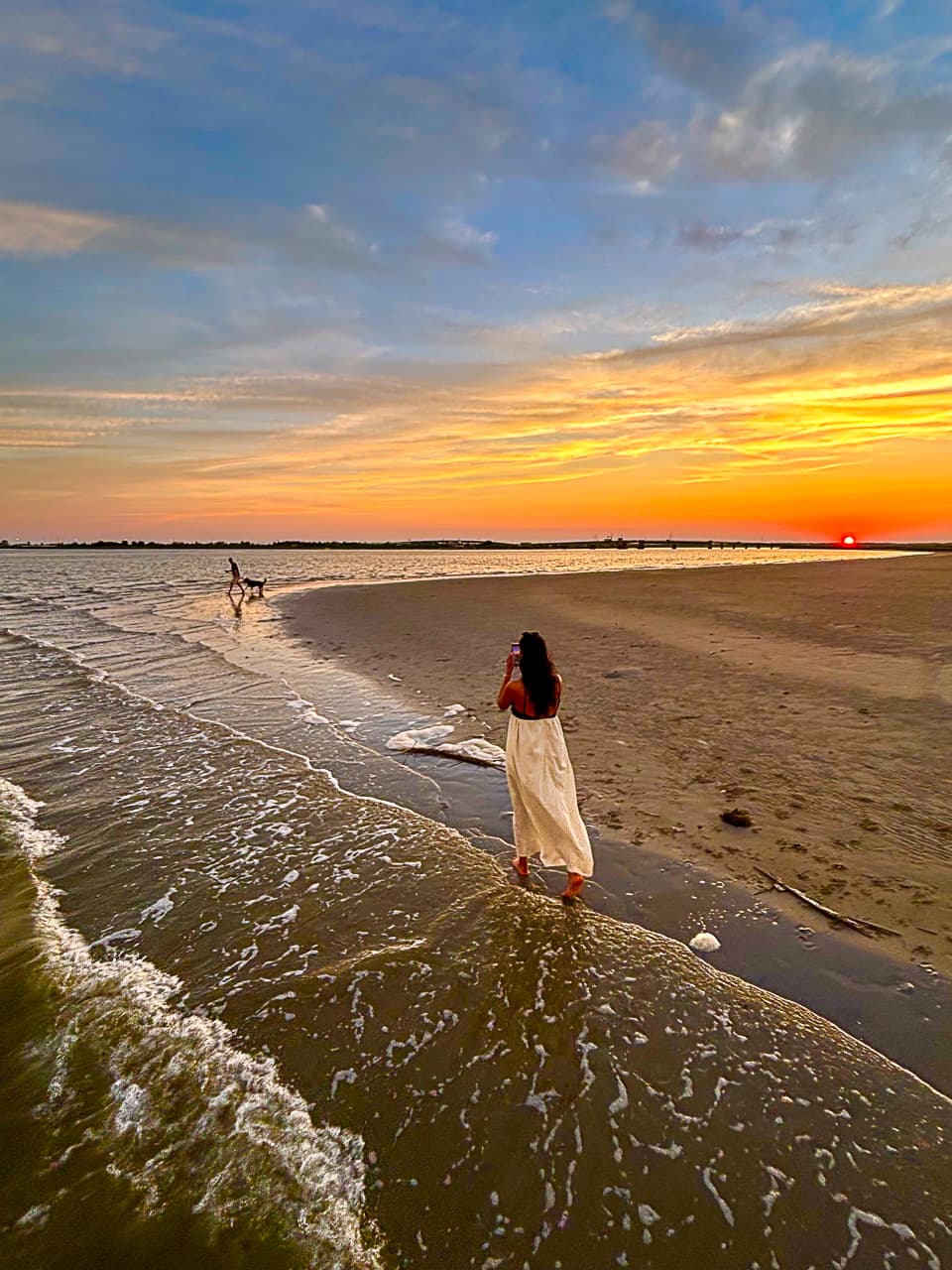 A guest walking the Champagne Island sandbar at sunset during a Sand Bar Joe's charter stop near Wildwood NJ